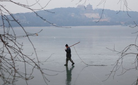 A worker walks across the frozen Kunming Lake at the Old Summer Palace in Beijing on Wednesday. Beijing topped the “green development” index but was second worst in a public satisfaction survey. Photo: Reuters