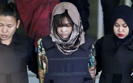 One of the suspects in Kim Jong-nam’s murder, Doan Thi Huong, is escorted by police as she leaves court. Photo: AP