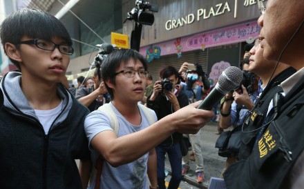 Scholarism convenor Joshua Wong Chi-fung (left) and Raphael Wong Ho-ming (centre) of the League of Social Democrats at a clearance operation at Mong Kok occupied site. Photo: K.Y. Cheng