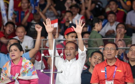 Indonesian President Joko Widodo (C) cheers during the men's team finals badminton match between China and Indonesia. Photo: EPA