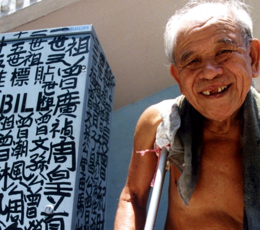 The self-appointed King of Kowloon, Tsang Tsou-choi, next to one of his works. Photo: courtesy of Birdy Chu
