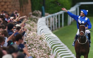 Hugh Bowman throws his goggles into the crowd after winning on Winx. Photo: Michael Dodge/Getty Images