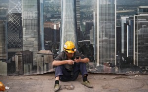 A worker takes a break outside a construction site in Beijing. The US-China trade war is likely to extend into the new year. The potential for further damage should help deter the countries from taking their threats too far. But the uncertainty from the trade tension may lead the world’s business community to consider restructuring global supply chains. Photo: AP
