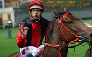 Jockey Hugh Bowman gives his trademark salute after winning on Country Star at Happy Valley. Photos: Kenneth Chan