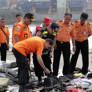 Indonesian rescuers collect and classify wreckage pieces and passenger belongings. Photo: EPA