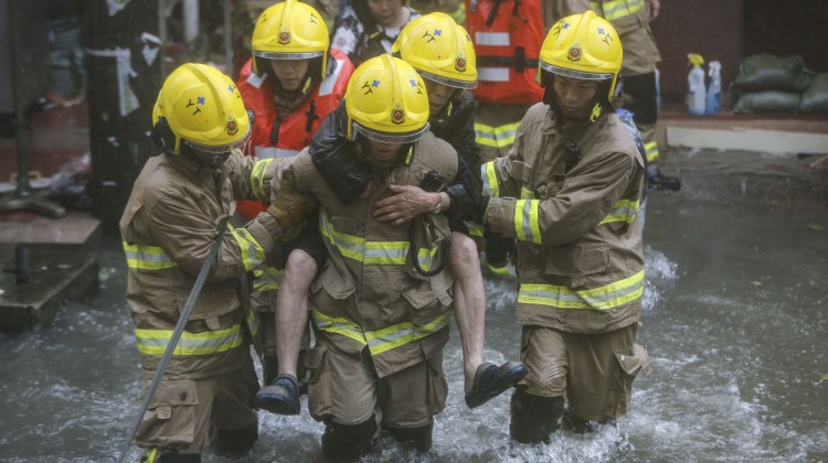 Firefighters help residents escape flooding in Lei Yue Mun, east Kowloon. Photo: Winson Wong