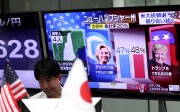 A Japanese worker at a foreign exchange trading company in Tokyo watches the US presidential elections unfold. Photo: AFP