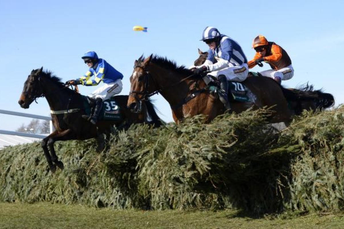 Winner Auroras Encore, ridden by Ryan Mania, and Teaforthree, ridden by Nick Scholfield (front), take a jump yesterday. Photo: AFP