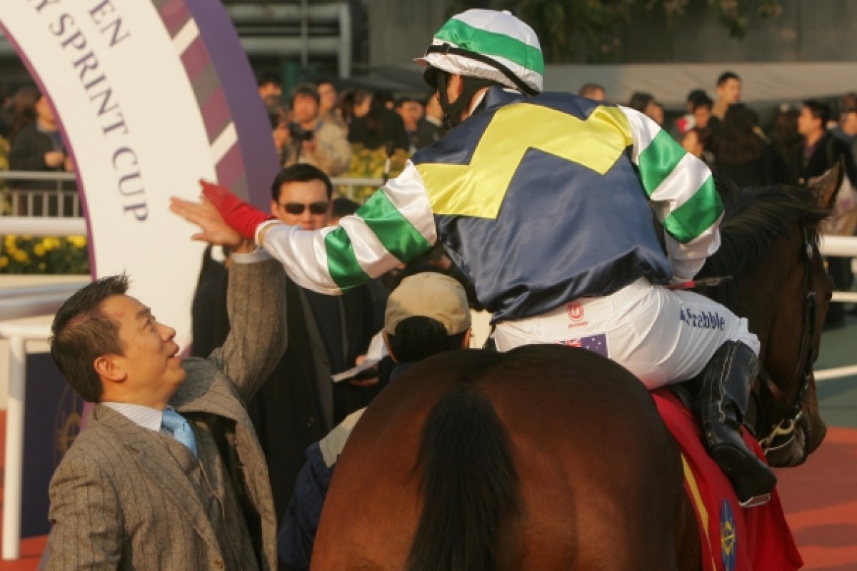Star horse trainer Ricky Yiu high-fives with rider Brett Prebble on Sacred Kingdom at the Sha Tin Racecourse on Jan 16, 2011. Photo: SCMP/ Kenneth Chan