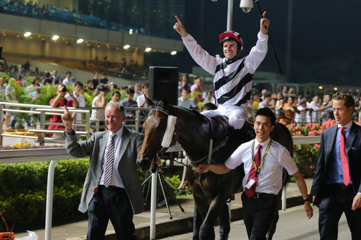 Trainer John Moore leads Dan Excel and jockey Tommy Berry to the winner's enclosure after defending their Singapore Airlines International Cup crown at Kranji in Singapore. Photos Kenneth Chan
                        