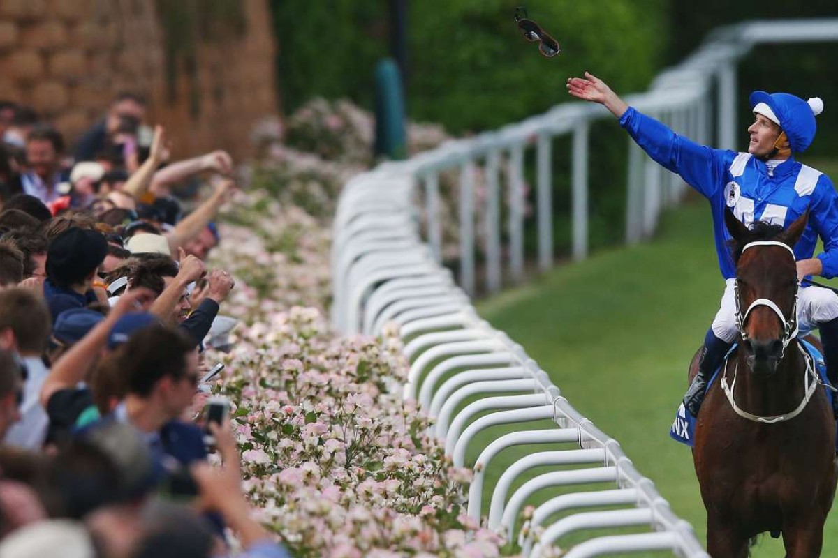 Hugh Bowman throws his goggles into the crowd after winning on Winx. Photo: Michael Dodge/Getty Images