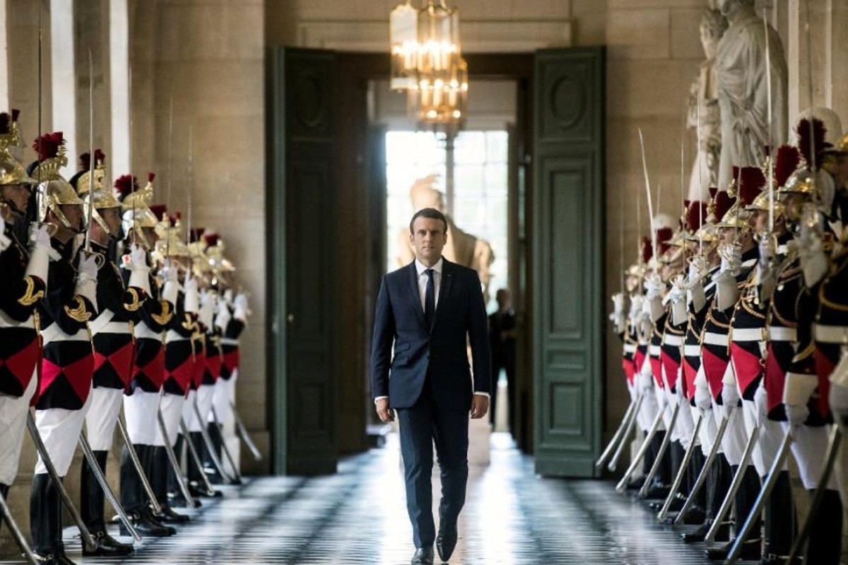 French President Emmanuel Macron walks through the Galerie des Bustes. Photo: REUTERS/Etienne Laurent
