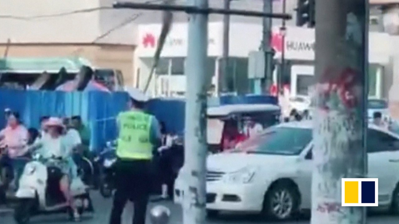 Chinese policeman props up cable with broomstick to keep traffic flowing